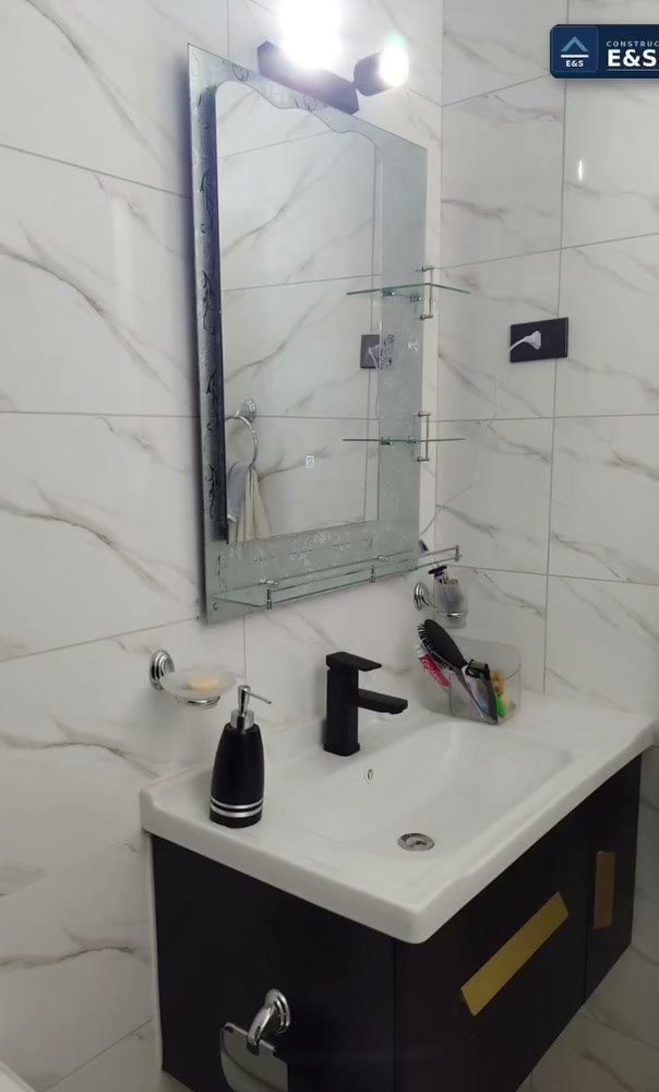 Mueble de baño flotante con grifería negra mate y espejo